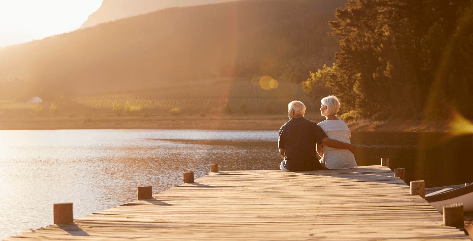 Coppia di anziani seduta in riva al lago